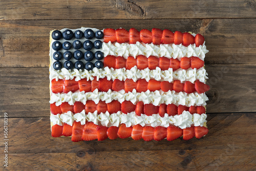 Cake with the colors of the US flag on a wooden background. Copy space.