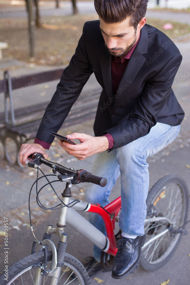 Young businessman talking on the phone while riding bicycle Young businessman talking on the phone while riding bicycle