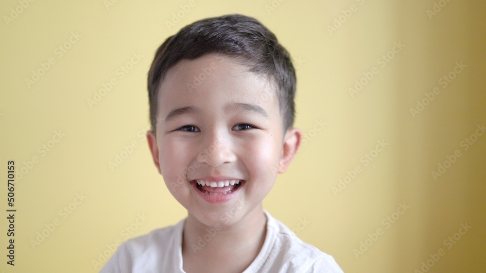 Cute boy looking at camera and laughing on colour background Cute boy looking at camera and laughing on colour background