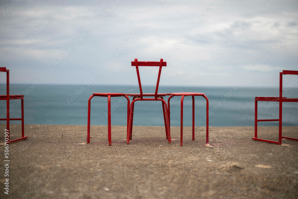 Red steel chairs on top of old bunker with a view of the Bay of Biscay in France Red steel chairs on top of old bunker with a view of the Bay of Biscay in France