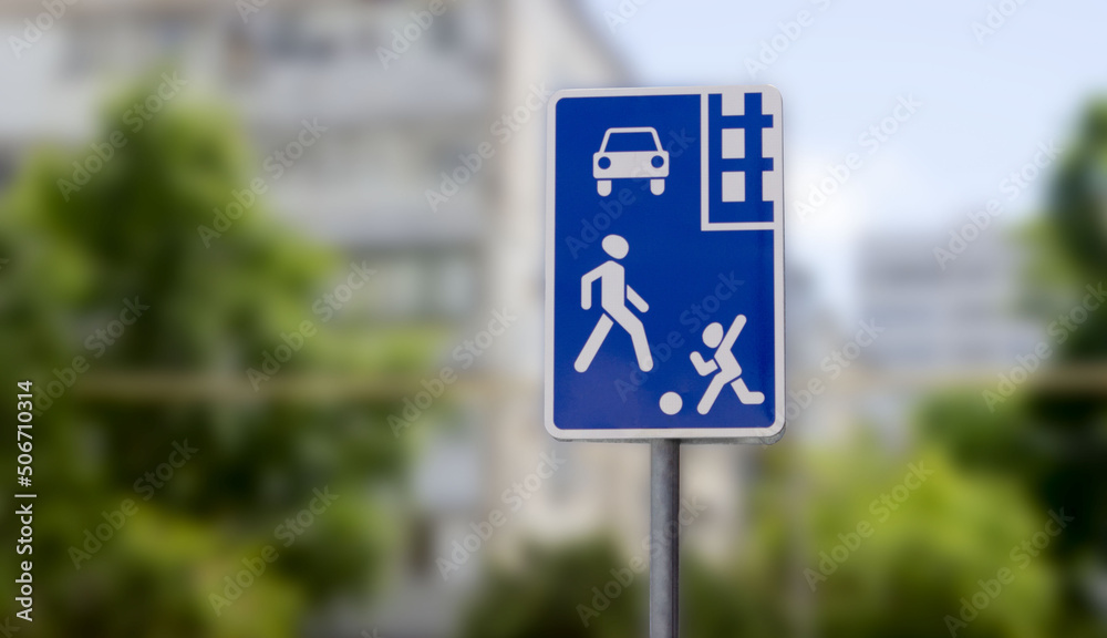 Road sign residential area on a blurred background. Square blue sign residential area on the background of houses Road sign residential area on a blurred background. Square blue sign residential area on the background of houses