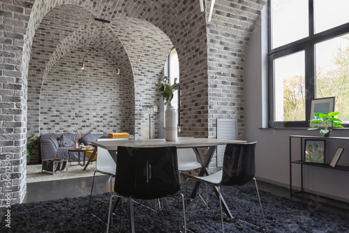 modern luxury design of a brutal apartment interior with arches in the style of a medieval castle with bright accents. free layout, kitchen area, seating and eating area.