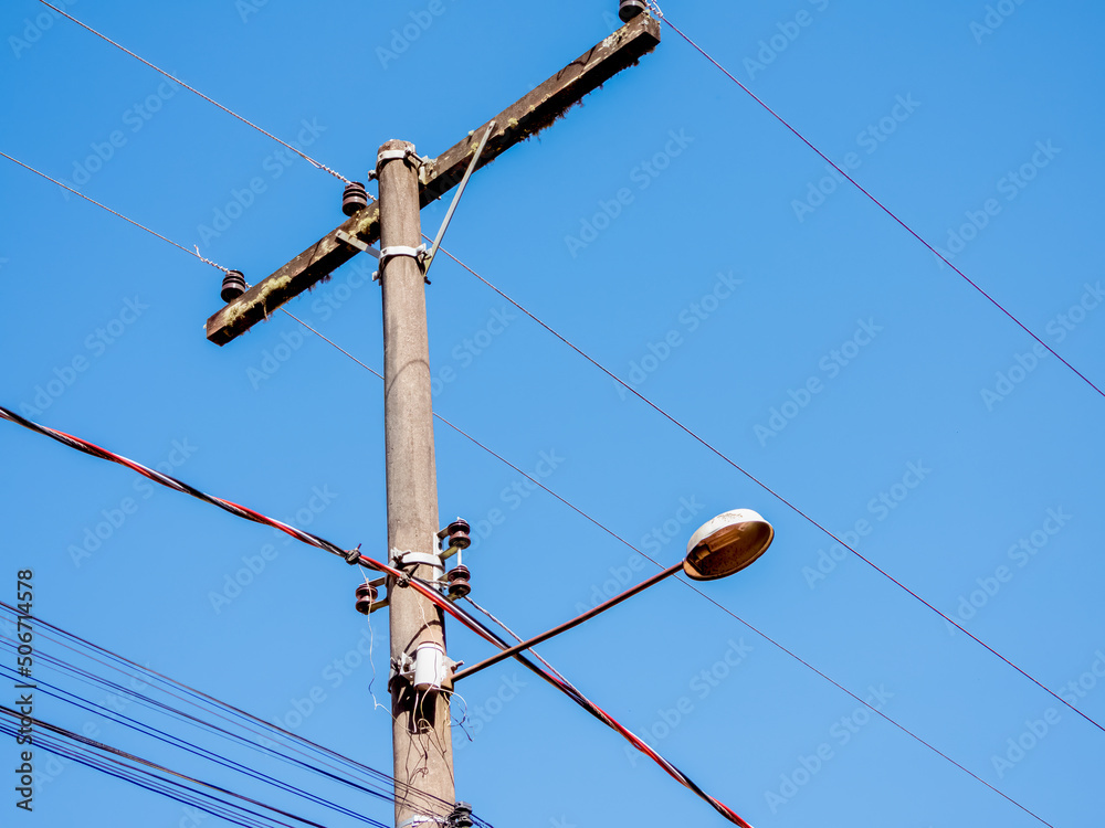 Street light lamp post in Brazil. Sunny day, clear skies. Lots of wires.