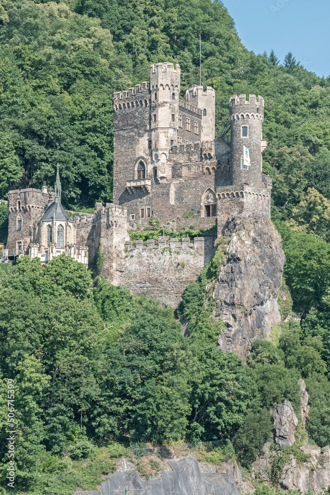 The 14th century Rheinstein Castle perched on a rocky promontory along the Rhine River in Germany.