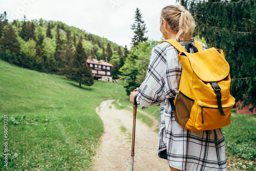 фотографія Lonely female with yellow backpack walking by mountain path with trekking poles to mount refuge hut in Slovakia, Mala Fatra region