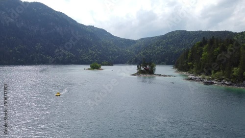 Europe Mini islands on a lake with boats and mountain landscape (Dolly forward and downwards)