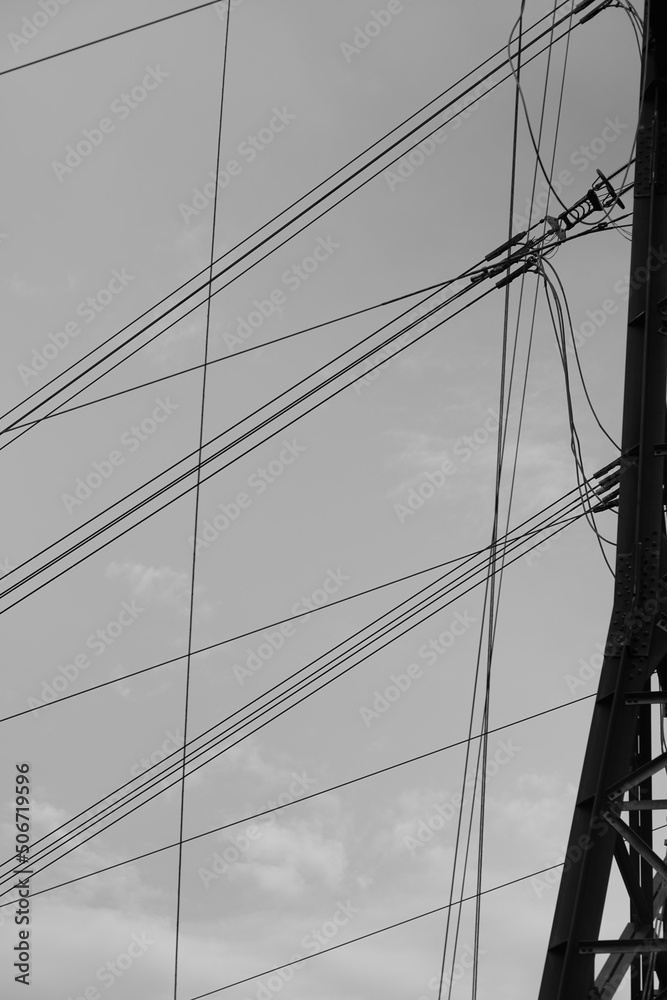 Fototapeta premium Elektrizität wird durch Kabel und Seile geleitet und transportiert, Hochspannung in einer Freileitung mit Mast