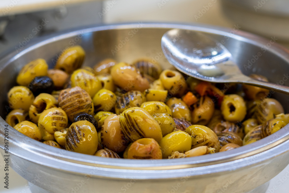Closeup of grilled marinated green olives in bowl on table Closeup of grilled marinated green olives in bowl on table