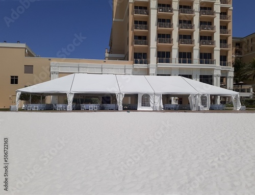 a large white events or entertainment tent on the beach