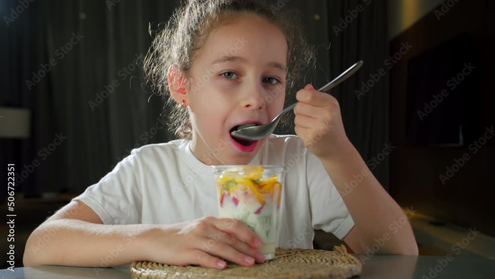 Child Eats Milk Yogurt With Tropical Fruits. Healthy Eating Little Girl 