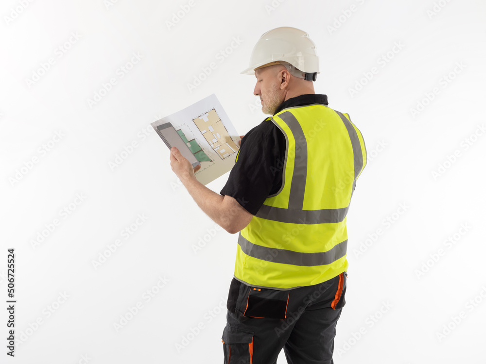 Construction foreman with a plan of the apartment in his hands. Master agrees on the details of the construction project via the Internet. Architect with a tablet and room plans on a white background. Construction foreman with a plan of the apartment in his hands. Master agrees on the details of the construction project via the Internet. Architect with a tablet and room plans on a white background.