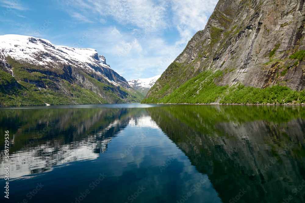 Geirangerfjord. Spring in the norwegian fjords. Reflections. Fishing. Waterfalls. Trees. Boats. Light and clouds. 
