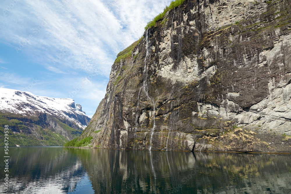 Geirangerfjord. Spring in the norwegian fjords. Reflections. Fishing. Waterfalls. Trees. Boats. Light and clouds. Geirangerfjord. Spring in the norwegian fjords. Reflections. Fishing. Waterfalls. Trees. Boats. Light and clouds.