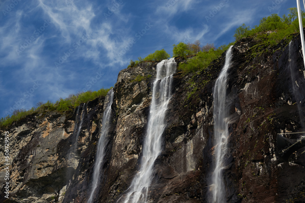 Geirangerfjord. Spring in the norwegian fjords. Reflections. Fishing. Waterfalls. Trees. Boats. Light and clouds. 