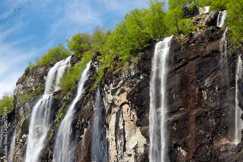Geirangerfjord. Spring in the norwegian fjords. Reflections. Fishing. Waterfalls. Trees. Boats. Light and clouds. 