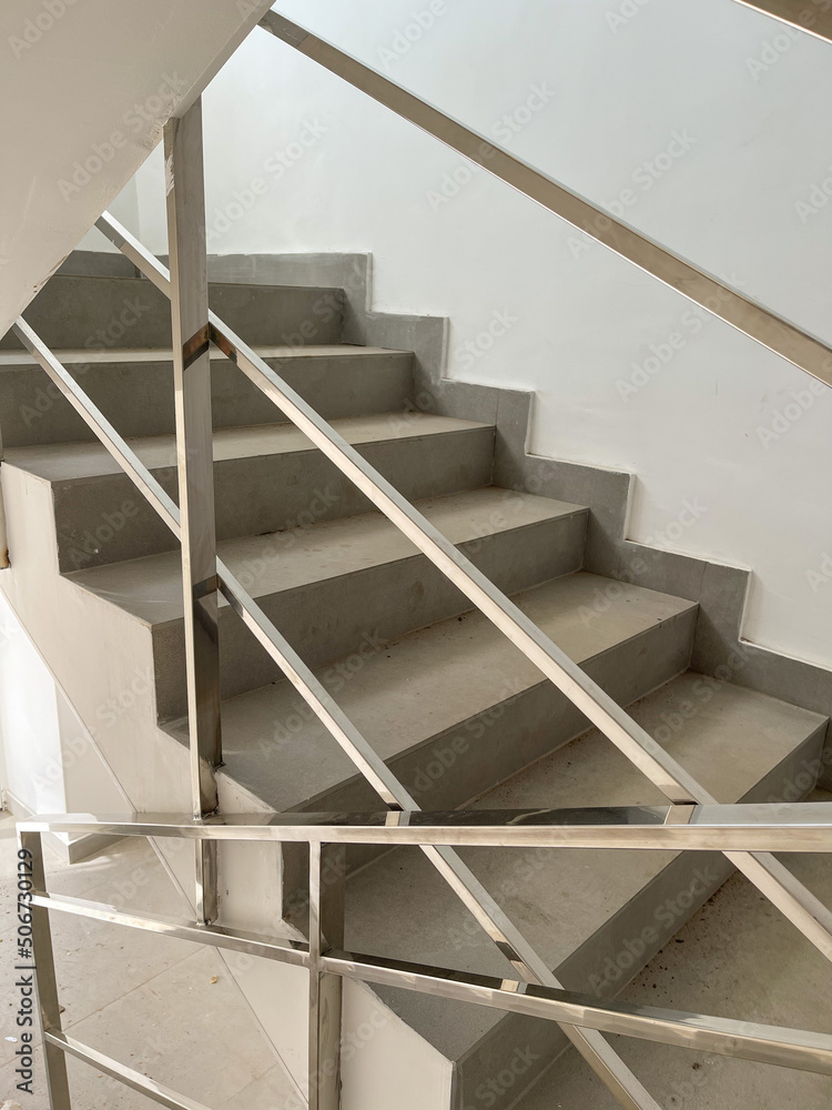 Concrete steps against white walls in a new house , construction concept Concrete steps against white walls in a new house , construction concept