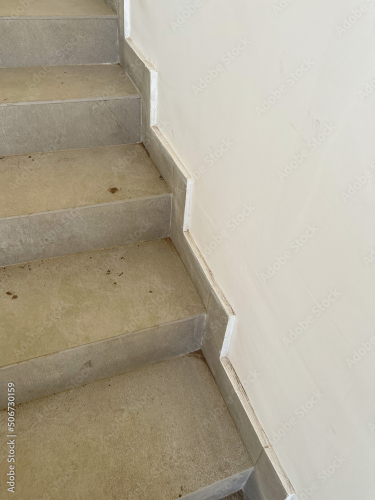 Concrete steps against white walls in a new house , construction concept Concrete steps against white walls in a new house , construction concept