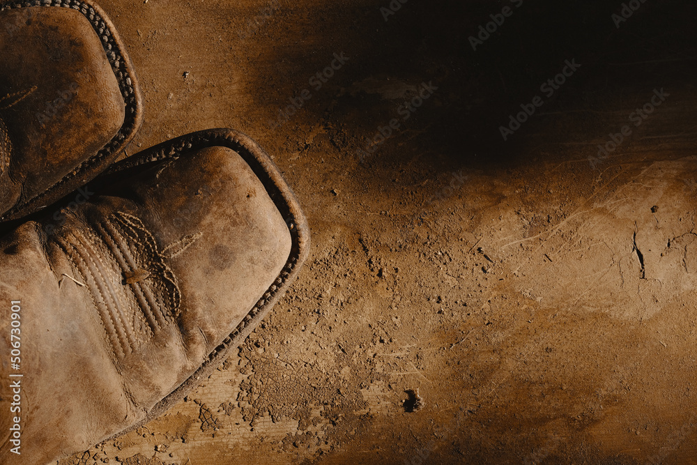 Cowboy boots on old vintage texture background for western wallpaper
