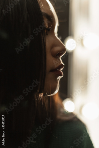 Women's close-up portrait of a beautiful Asian girl in the dark