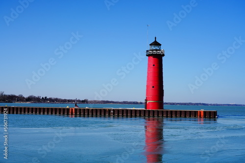 Red lighthouse standing in the bay of Lake Michigan 