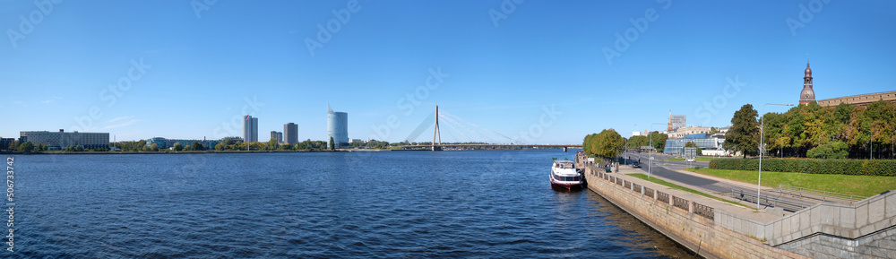 Panoramic view of the Baltic Capital of Riga Latvia. Embankment, view of the riverside with tourist ship and modern skyscrapers. Sunny day in Summer.