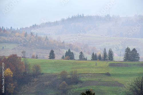 Cloudy and foggy autumn mountains scene. Peaceful picturesque traveling, seasonal, nature and countryside beauty concept scene. Carpathian Mountains, Ukraine. photo