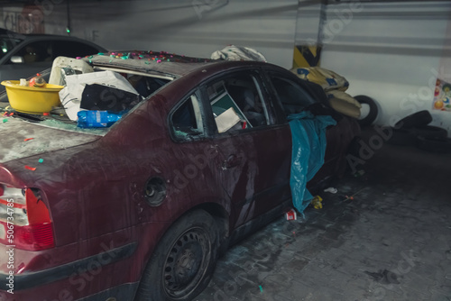 destroyed car with a flat tire and rubish on it in the underground parking. High quality photo