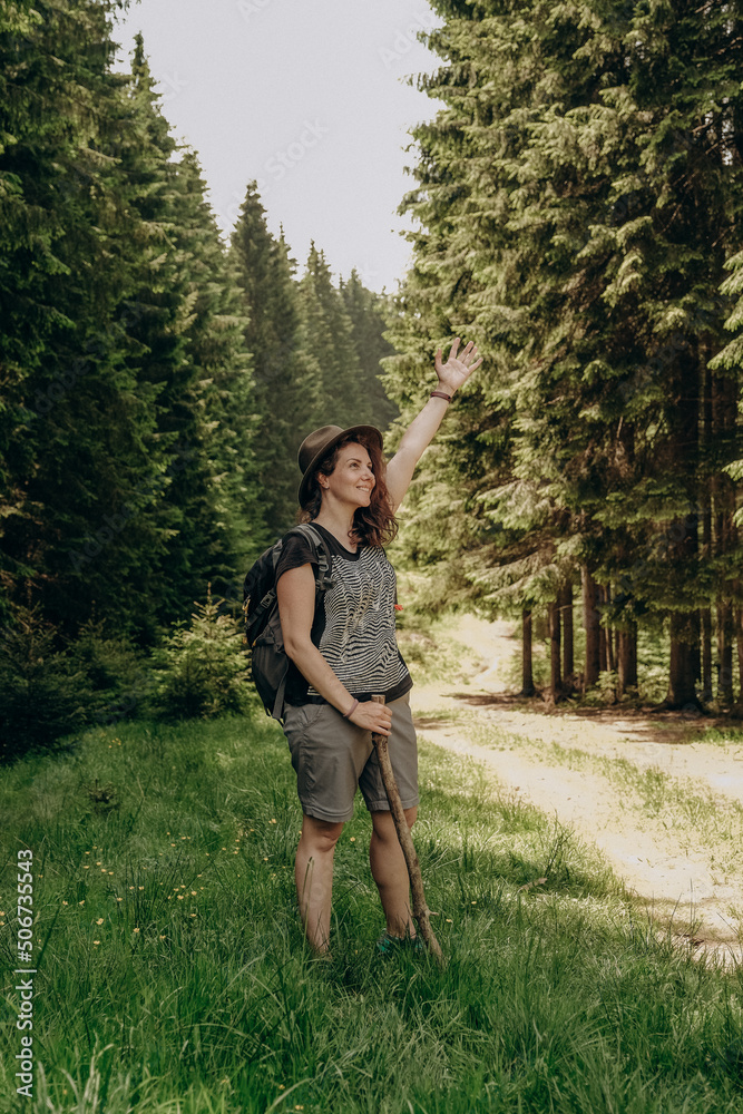 Summer trip to the mountains. A woman walks in the forest in summer. Hiking in the mountains. Active holiday in summer. Summer trip to the mountains. A woman walks in the forest in summer. Hiking in the mountains. Active holiday in summer.