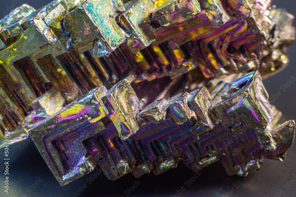 Fototapeta premium Bismuth bi close up on black surface.Interesting colour and shape crystal. Metal crystal