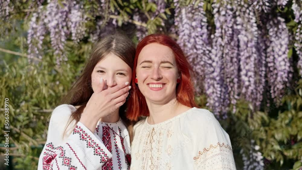 Two Ukrainian girlfriends in national traditional clothes vyshyvanka hug and smile in the summer nature in the countryside. Two Ukrainian girlfriends in national traditional clothes vyshyvanka hug and smile in the summer nature in the countryside.