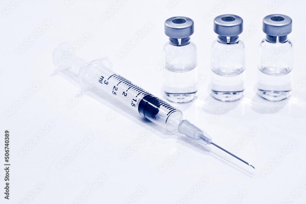 Vial of Drug or Vaccine and 3 ml Plastic Syringe with Needle Isolated on the White Background, blue tone color Vial of Drug or Vaccine and 3 ml Plastic Syringe with Needle Isolated on the White Background, blue tone color