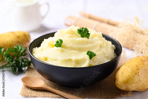 Mashed potato with pasley in black bowl on white background photo