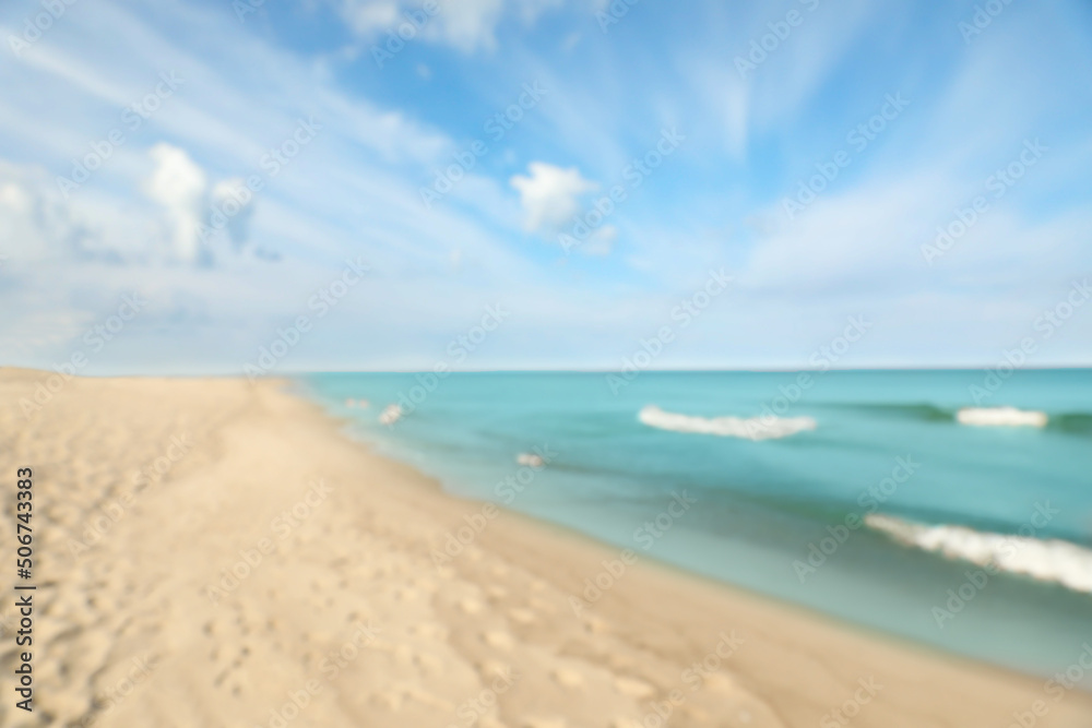 Blurred view of sea shore and blue sky on sunny day Blurred view of sea shore and blue sky on sunny day