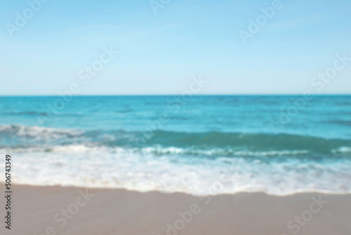 Blurred view of beautiful sea and sandy beach on sunny day