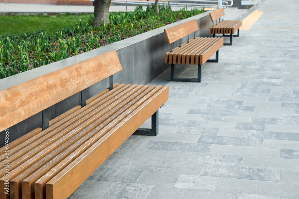 Paved city street with comfortable wooden benches Paved city street with comfortable wooden benches