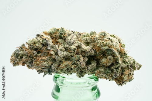 Purple and Green Coloured Cannabis Flower on a Glass Bottle