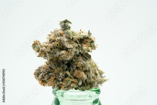 Purple and Green Coloured Cannabis Flower on a Glass Bottle