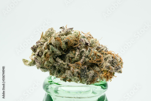 Purple and Green Coloured Cannabis Flower on a Glass Bottle