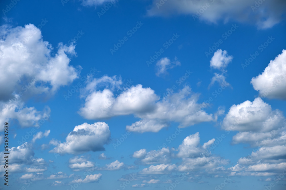 Bright landscape of white puffy cumulus clouds on blue clear sky Bright landscape of white puffy cumulus clouds on blue clear sky