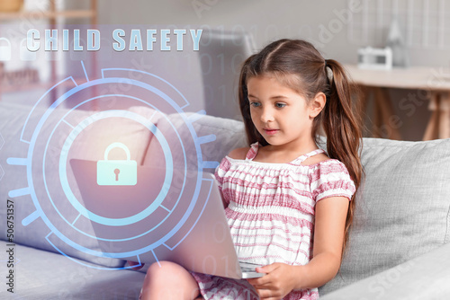 Cute little girl with laptop at home. Concept of safety and parental control
