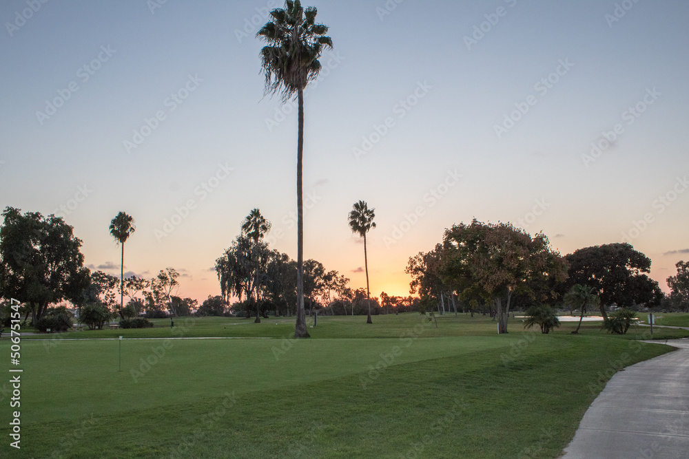 View of golf course with sun setting on the background View of golf course with sun setting on the background
