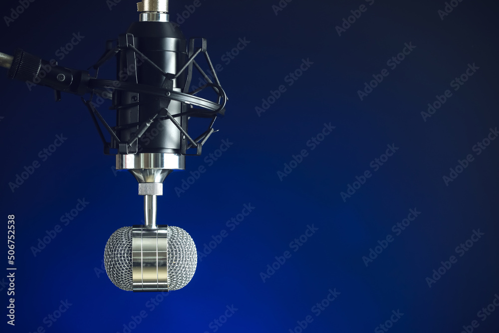 Stand with microphone on blue background, closeup Stand with microphone on blue background, closeup