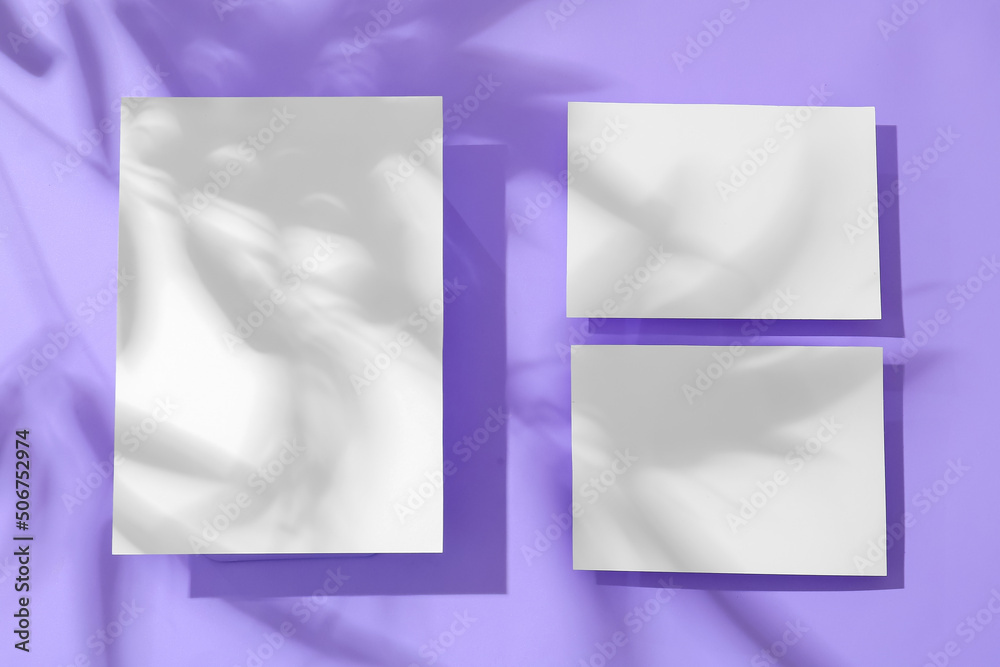 Blank paper sheets and shadows on lilac background Blank paper sheets and shadows on lilac background