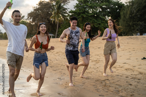 Group of Asian young man and woman having party on the beach together. 