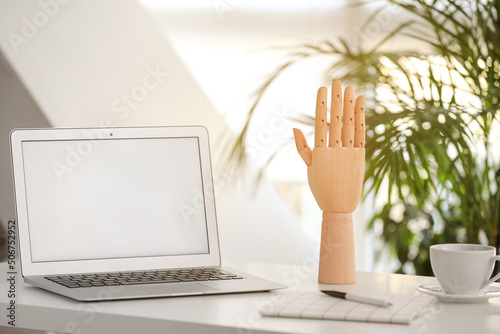 Wooden hand and laptop on t...