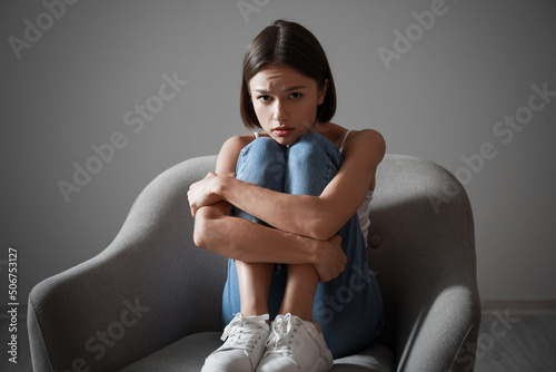 Sad young woman sitting in ...