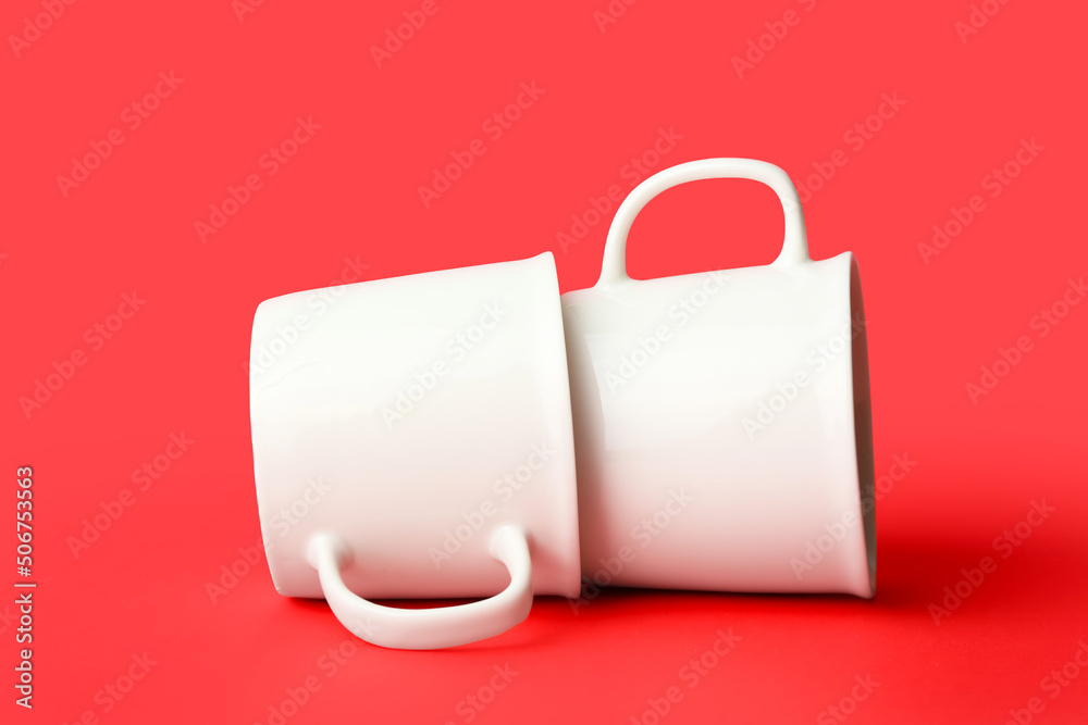 Two ceramic cups on red background Two ceramic cups on red background