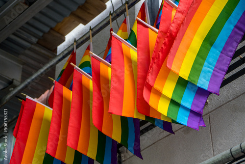 New York, NY - USA - May 20 2022 Closeup of a line of Rainbow flags hung above The Stonewall Inn. Gay bar & National Historic Landmark, site of the 1969 riots that launched the gay rights movement.