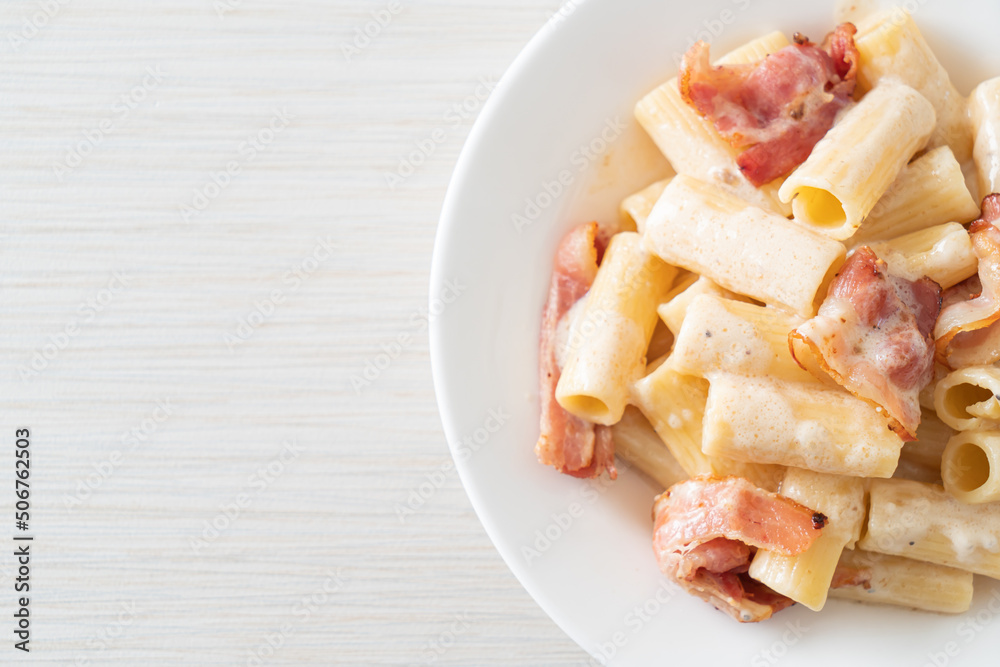 spaghetti rigatoni pasta with white sauce and bacon