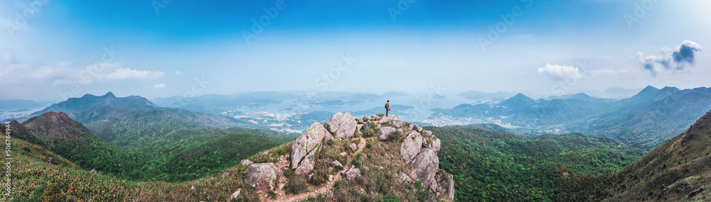 panorama of Man standing on the rock, hiking in Sai Kung, Hong Kong